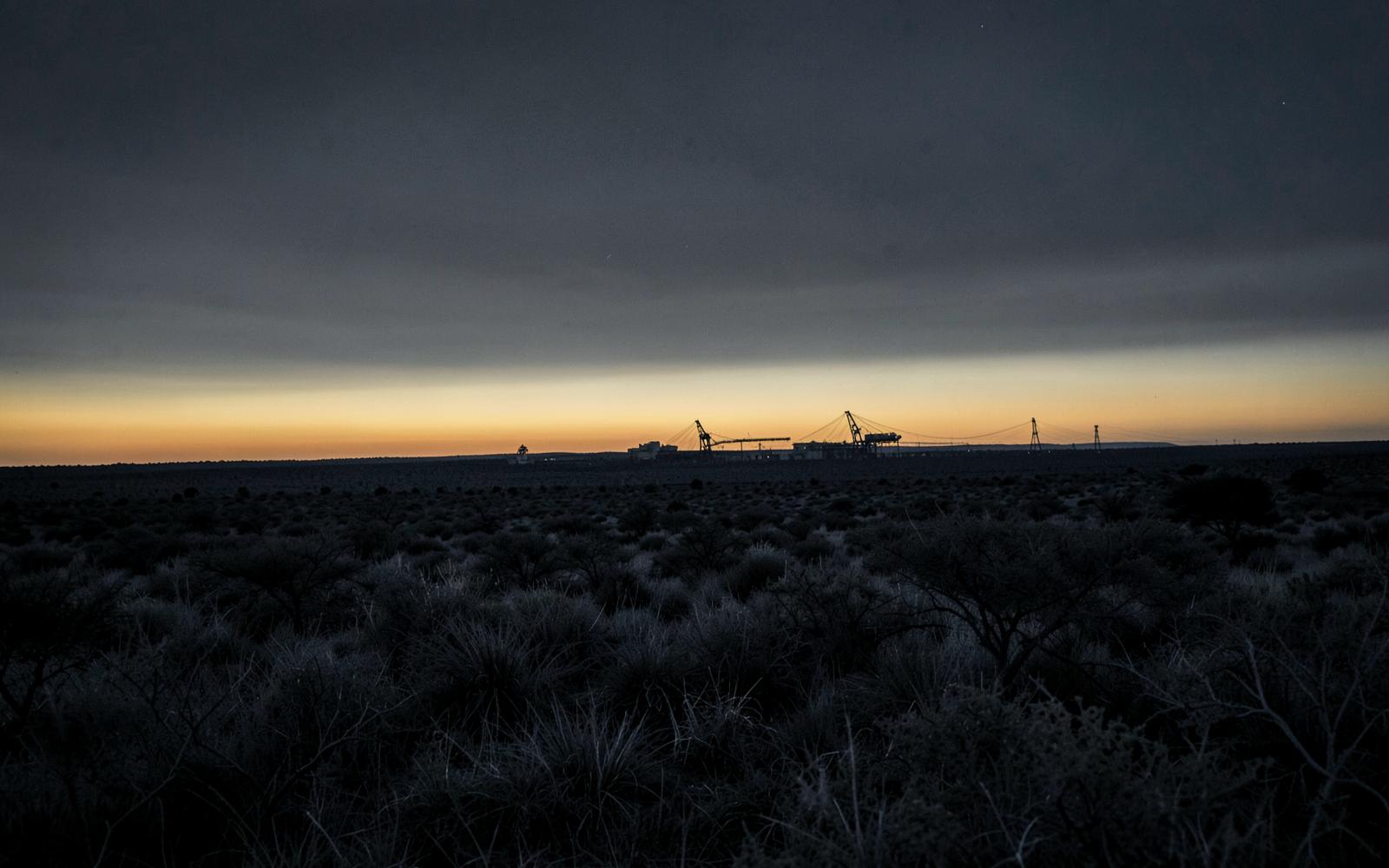 Southern African plateau at dusk with distant mine infrastructure